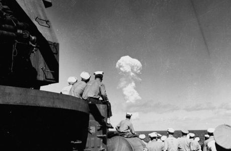 The newly declassified images show the World War II aircraft carrier which was one of nearly a hundred ships used as targets in the first tests of the atomic bomb at Bikini Atoll in 1946. Here, Sailors watch the 'Able Test' burst miles out to sea from the deck of the support ship USS Fall River on 1 July 1946. Image: Naval Archives