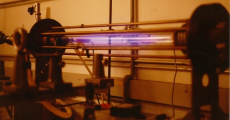 Laboratory scale Z-pinch showing glow from an expanded hydrogen plasma. Pinch and ionisation current flows through the gas and returns via the bars surrounding the plasma vessel.